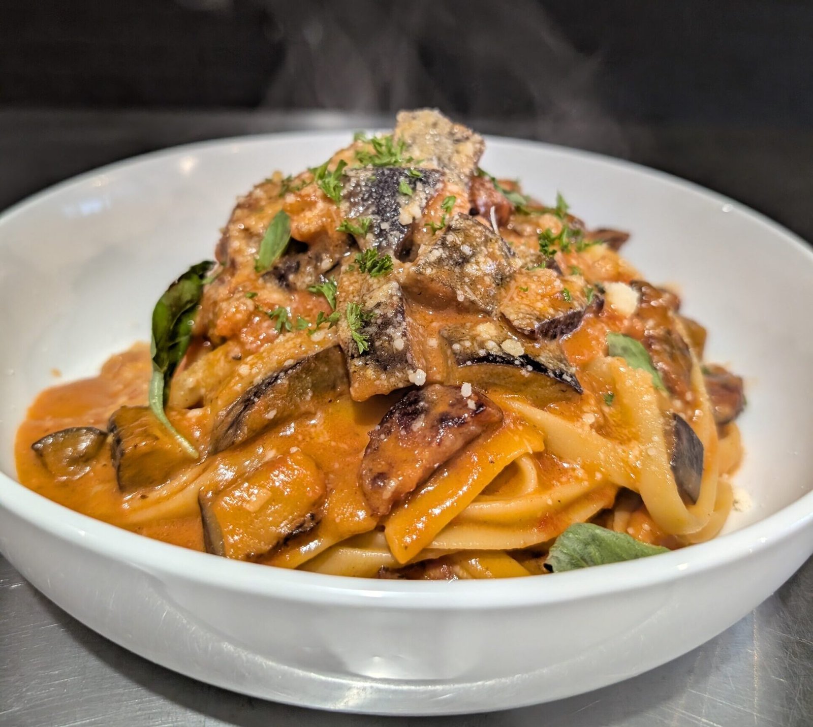 Chorizo and eggplant pasta tossed in a rich tomato-cream sauce, garnished with basil and parmesan.